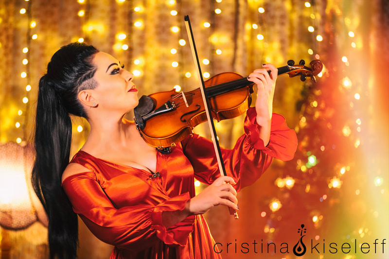 Cristina Electric Violinist in a festive red dress playing Christmas Carols on violin