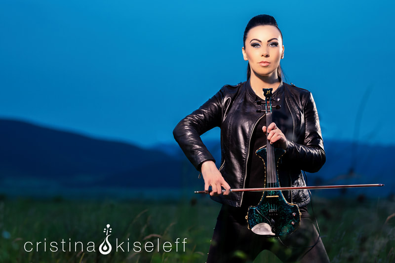 Cristina Kiseleff Electric Violinist dressed in a black rock leather jacket and pants playing a Bridge green marble violin