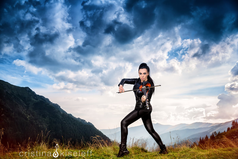 Cristina Kiseleff Electric Violinist dramatic portrait at a mountain top with a tight rock leather outfit