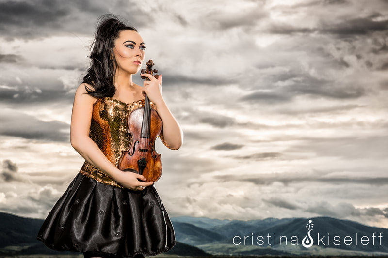 Cristina Kiseleff Electric Violinist with a golden mermaid scales corset cloudy gray sky mountain epic portrait