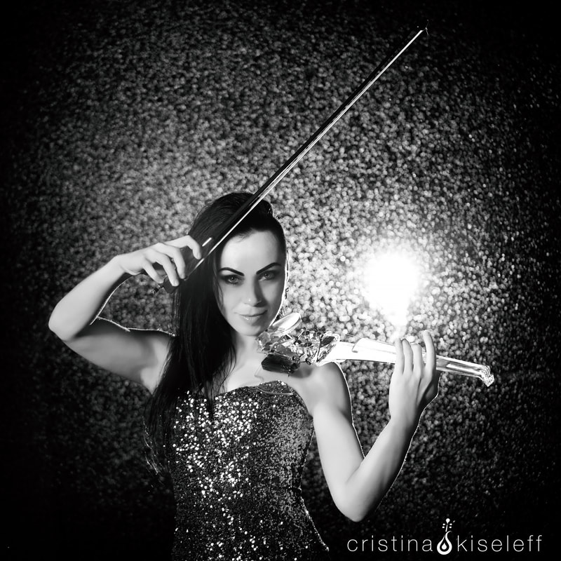 Cristina Kiseleff Electric Violinist playing an acrylic transparent crystal violin in the rain