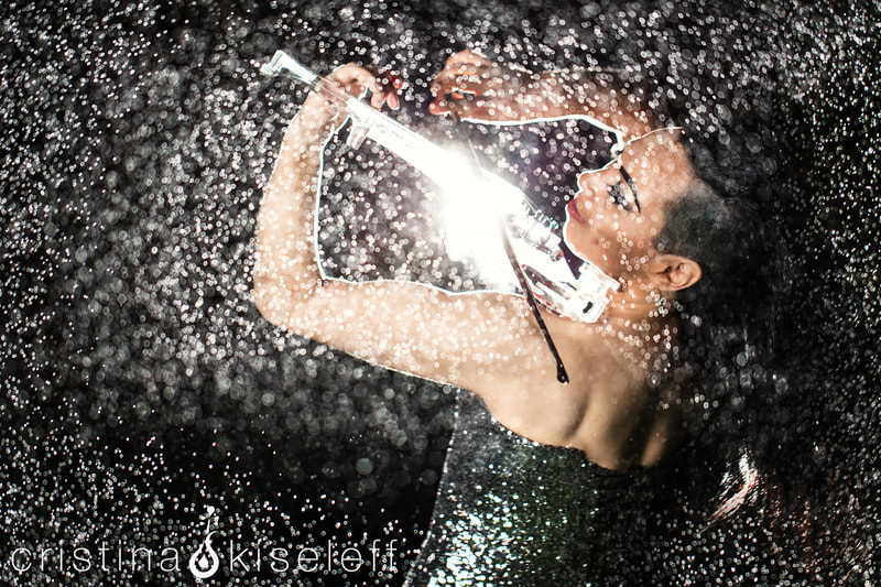 Cristina Kiseleff Electric Violinist Performing in the rain with a crystal acrylic transparent violin and a shiny corset